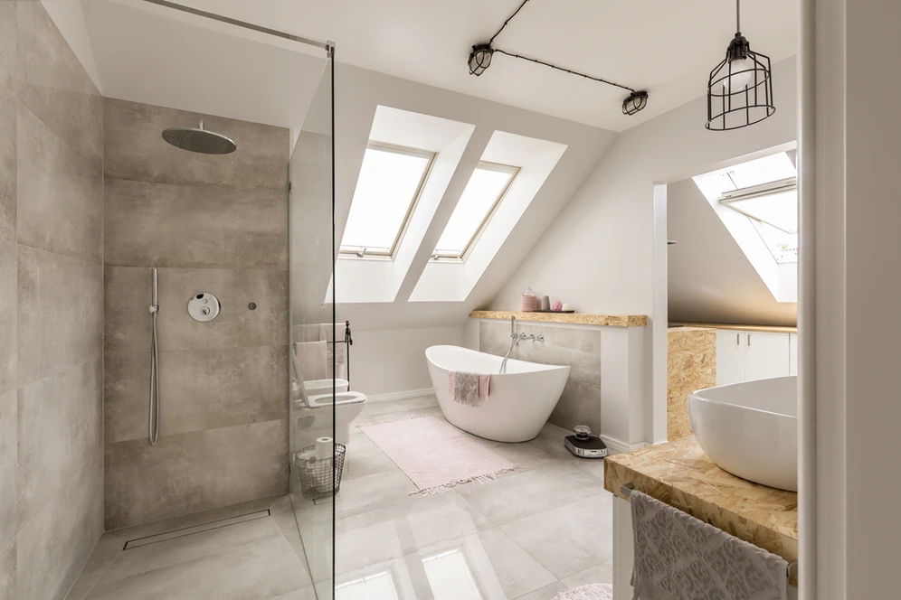 A bathroom with a white tub, a sleek sink, and a window overlooking a serene view.